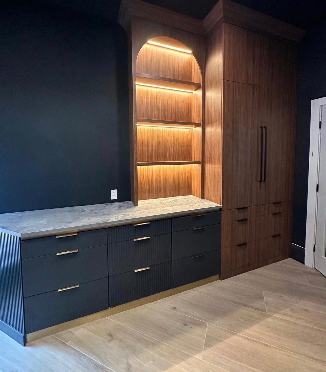 Custom cabinetry with lighted walnut shelving